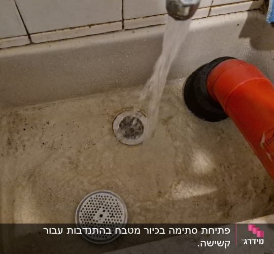 כיור עם מים זורמים וצינור אדום